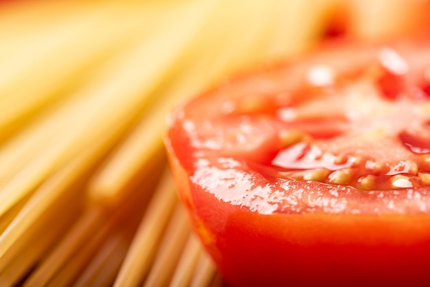 Pasta schöne Details von roten Tomaten und Strängen von rohen Spaghetti über rustikalem Holz selektiven Fokus