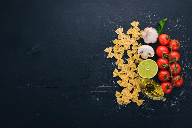 Pasta seca Farfalle con verduras Sobre un fondo de madera Vista superior Espacio de copia