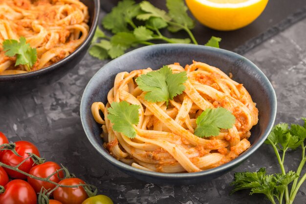 Pasta de sémola con salsa de tomate al pesto, naranja y hierbas. Vista lateral