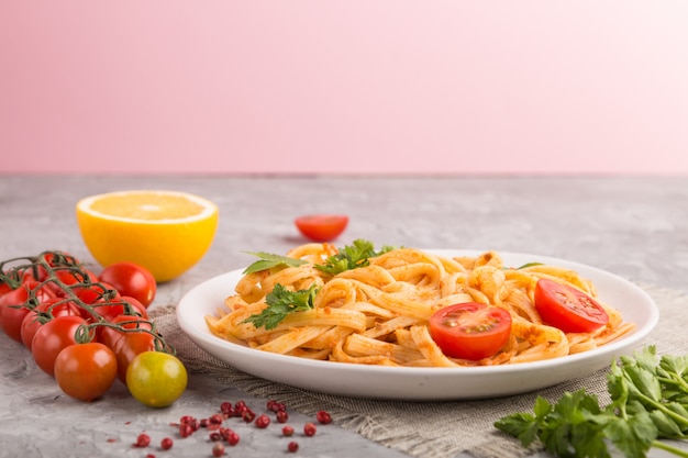 Pasta de sémola con salsa de tomate al pesto, naranja y hierbas. Vista lateral