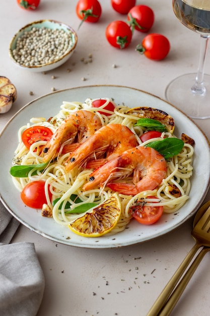 Pasta Spaghetti mit Garnelen, Tomaten, Knoblauch, Spinat und Zitrone. Italienische Küche. Meeresfrüchte. Diät.