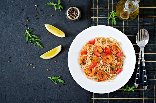 Pasta Spaghetti mit Garnelen, Tomaten und Petersilie. Gesundes Essen. Italienisches Essen. Draufsicht. Flach liegen