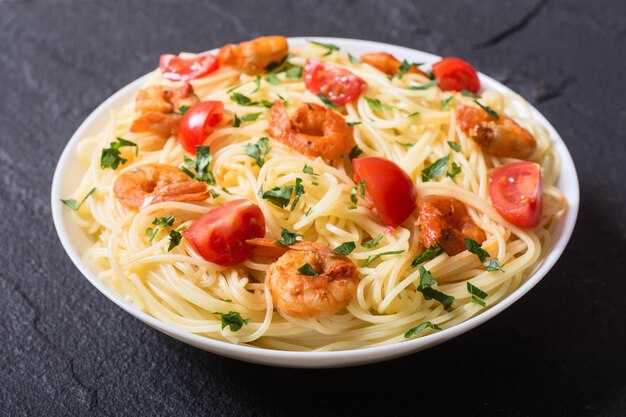 Pasta-Spaghetti mit Garnelen, Tomaten und Petersilie. Meeresfrüchte-Hintergrund