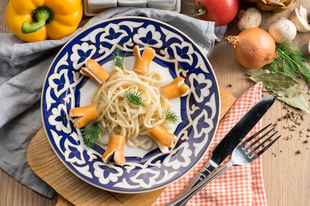 Pasta Spaghetti mit Salzwürsten und Dill in einem Teller mit einem traditionellen Usbeken