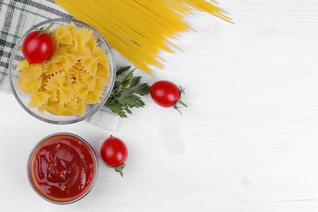 Pasta Spaghetti und Farfalle mit roter Kirschtomatensauce und Petersilie auf einer Serviette