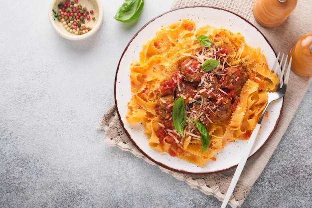 Pasta tagliatelle con albóndigas en salsa de tomate y tomillo en salsa sobre piedra de pizarra gris claro o fondo de hormigón Cocina y plato italiano tradicional Vista superior con espacio para copiar