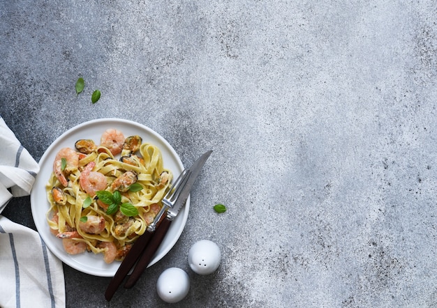 Pasta de tallarines con mariscos y parmesano en una vista de placa desde arriba