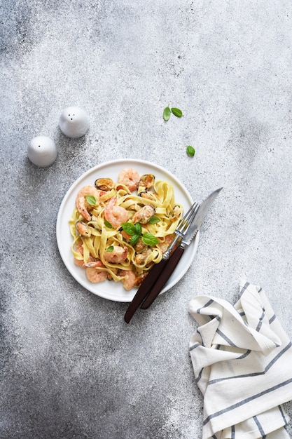 Pasta de tallarines con mariscos y parmesano en una vista de placa desde arriba