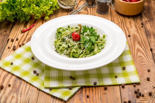 Pasta de tallarines con pesto de espinacas y guisantes verdes, enfoque selectivo