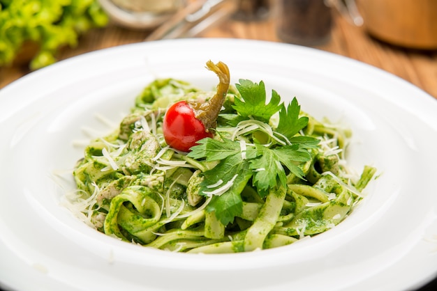 Pasta de tallarines con pesto de espinacas y guisantes verdes, enfoque selectivo