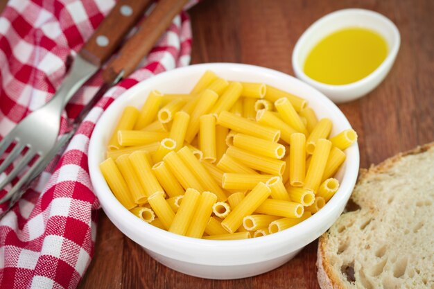 Pasta en un tazón con pan y aceite de oliva.