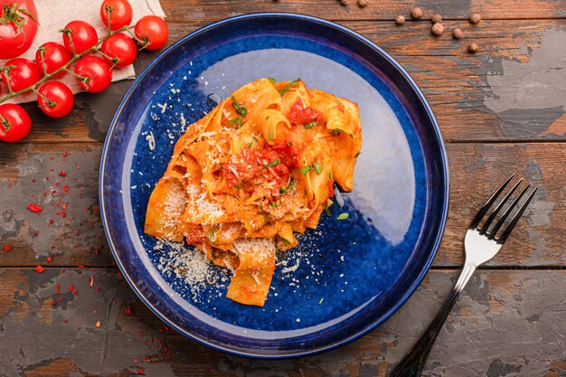 Pasta con tomate y parmesano, sobre un fondo de madera