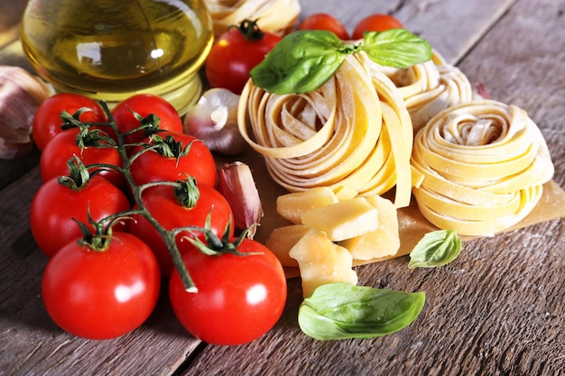 Pasta con tomates cherry y otros ingredientes sobre fondo de mesa de madera