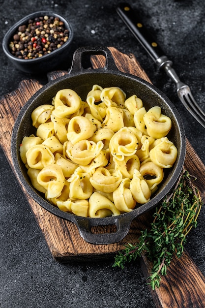 Pasta tortellini italiano con salsa de queso en una sartén.