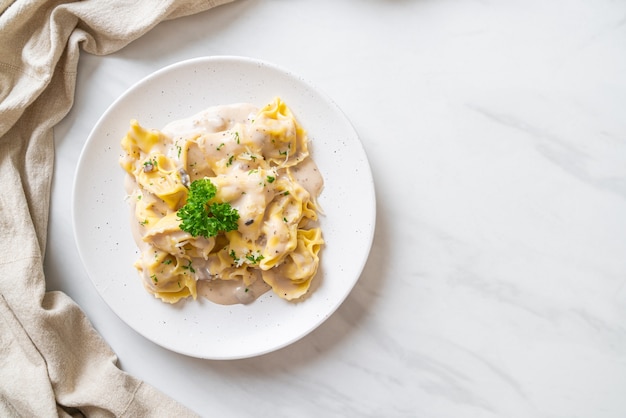 pasta tortellini con salsa de crema de champiñones y queso. Estilo de comida italiana