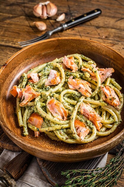 Pasta tradicional italiana al salmón, pasta Bucatini con salmón ahumado. Fondo de madera. Vista superior.