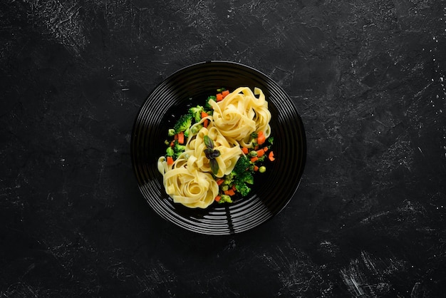 Pasta con verduras Fideos Vista superior Sobre un fondo negro Espacio de copia libre