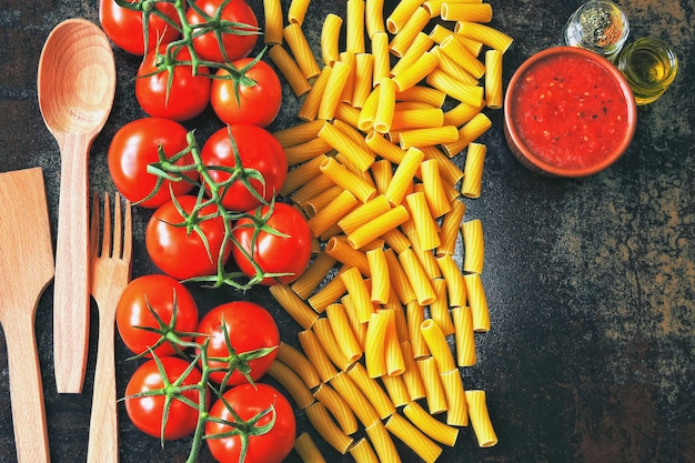 Pastas crudas y tomates en la rama. Concepto de cocina pasta con salsa de tomate.