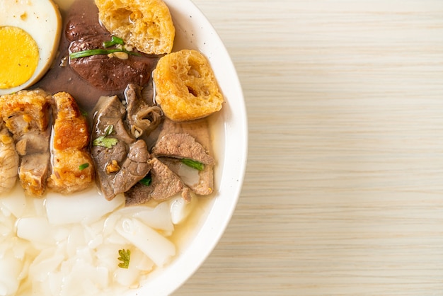 Paste aus Reismehl oder gekochtem chinesischem Nudelquadrat mit Schweinefleisch in klarer Suppe. Asiatischer Essensstil