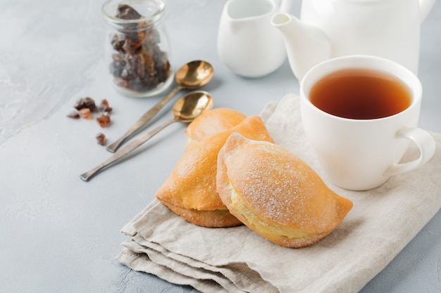 Pastéis com queijo cottage e açúcar de confeiteiro em um fundo de pedra cinza ou concreto Pastelaria tradicional russa Sochnik