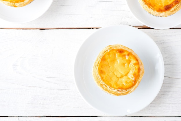 Pasteis de nata, pastelaria típica portuguesa de torta de ovo em uma mesa posta. Vista superior com espaço de cópia