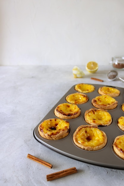 Pastéis de nata portugueses pastel de nata ou pastel de Belém na forma cinzenta sobre a mesa cinzenta