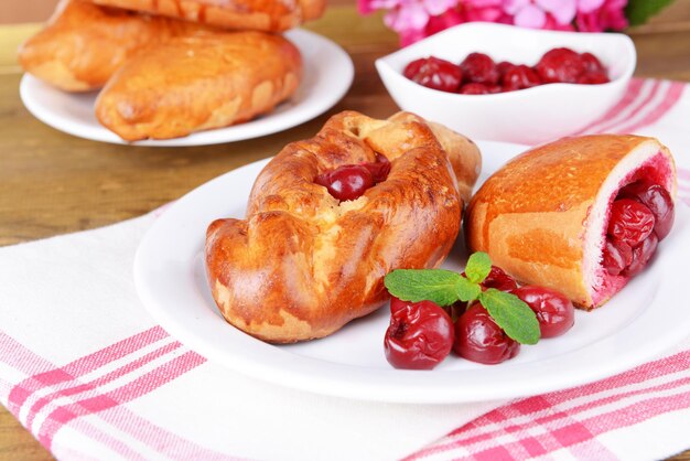 Pastéis frescos assados com cereja no prato na mesa closeup