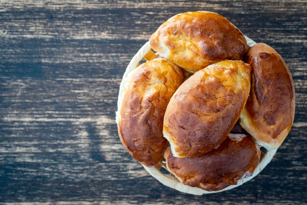 Pastéis recém-assados recheados com cebola verde e ovo em uma madeira