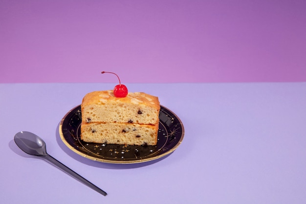 Pastel de alto ángulo con cereza en un plato