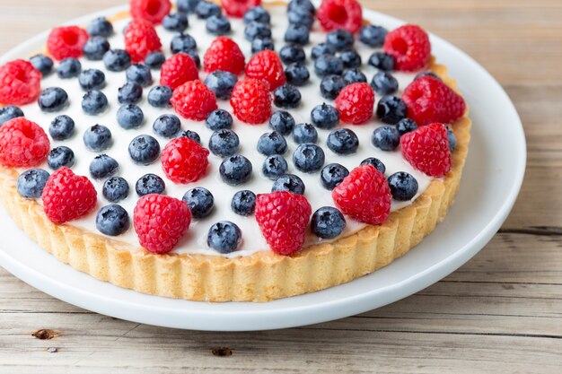 Pastel con arándanos y frambuesas. Producto de confitería.