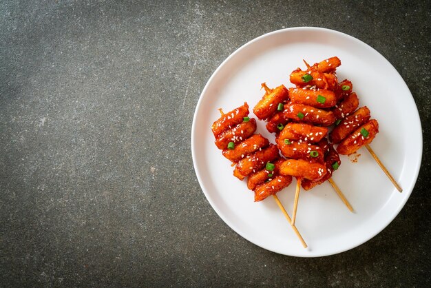 pastel de arroz coreano frito (Tteokbokki) ensartado con salsa picante - estilo de comida coreana