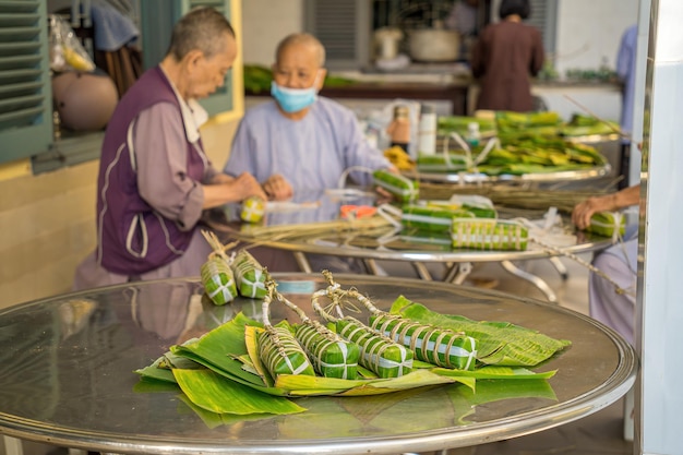 Pastel de arroz pegajoso vietnamita pastel tet Comida tradicional vietnamita de año nuevo la comida más importante del año nuevo lunar vietnamita Tet Focus paquete de pastel tet con fondo borroso