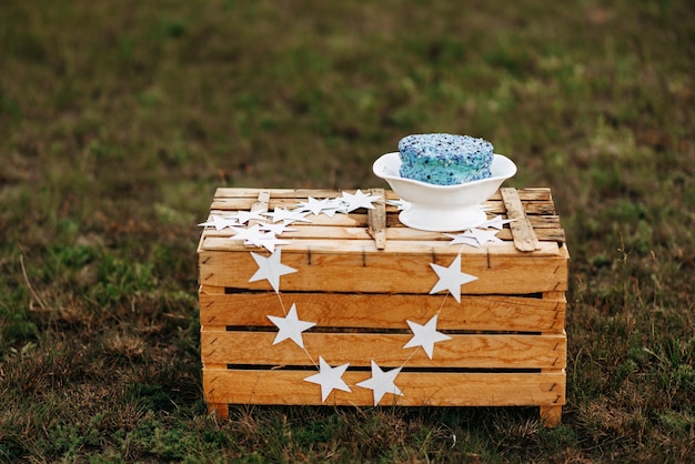 un pastel azul en un soporte de madera