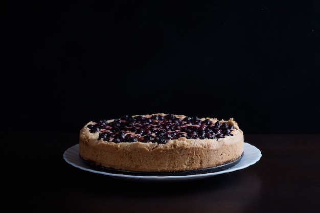 Pastel de bayas de las cerezas pasas en un cuenco de vapor fresco un todo y rodajas de superficie caliente borrosa