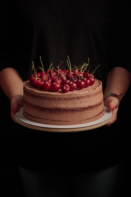 Pastel con bayas en manos de mujer