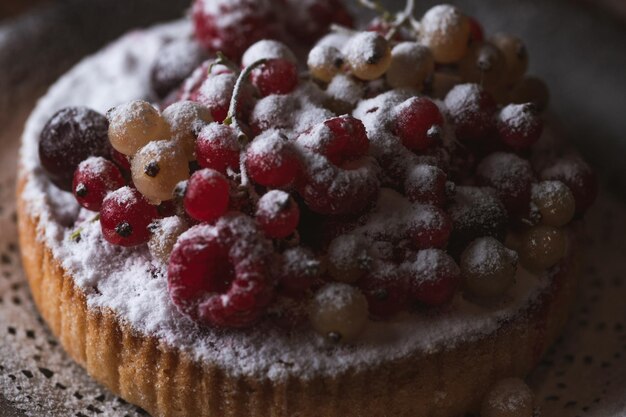 Foto el pastel con bayas está salpicado de azúcar en polvo