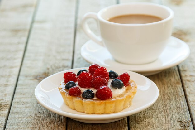 Pastel con bayas y taza de café