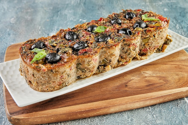 Pastel de berenjena con salsa de tomate y aceitunas. Cocina gourmet francesa