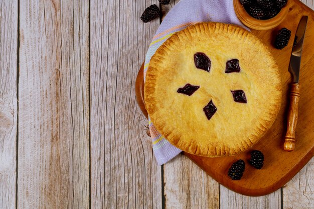 Pastel de Blackberry en mesa de madera con cuchillo.