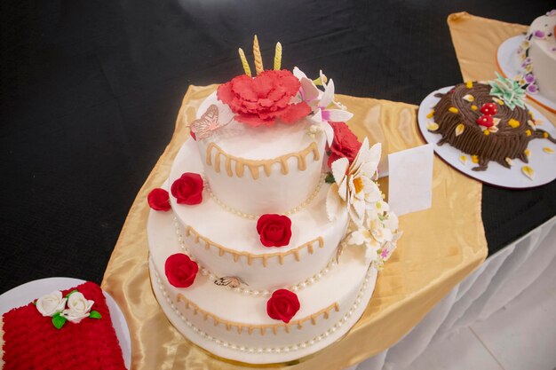 Pastel de boda con rosas rojas en la parte superior con fondante