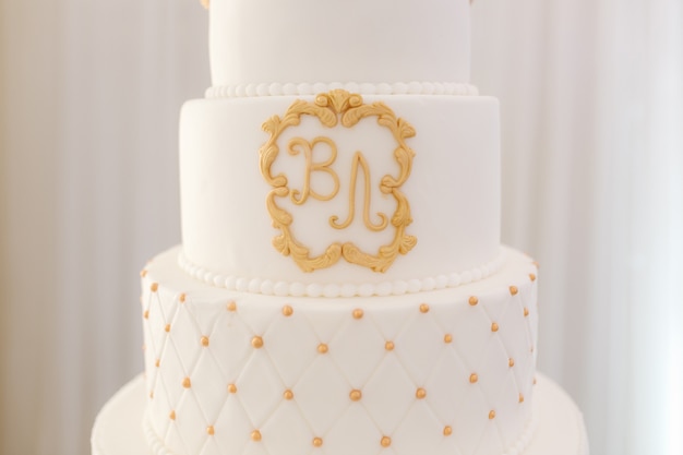 Pastel de bodas blanco de cinco pisos decorado en estilo dorado hermosos dulces para el novio y la novia