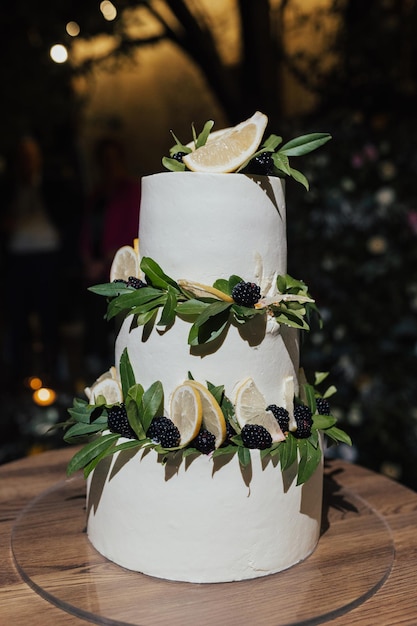 Un pastel de bodas blanco con limones y moras.