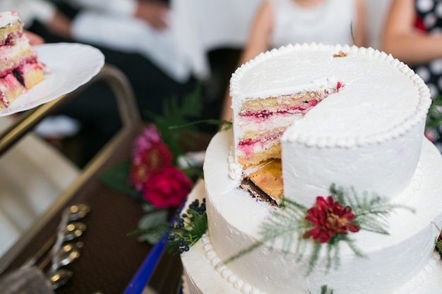 Pastel de bodas blanco de varios niveles con decoraciones florales