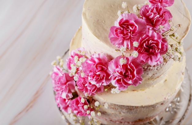 Pastel de bodas desnudo decorado con flores rosas