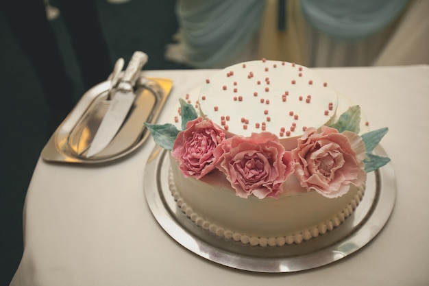 El pastel de bodas está decorado con flores rosas.