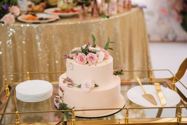 Pastel de bodas con flores en un carro en una boda