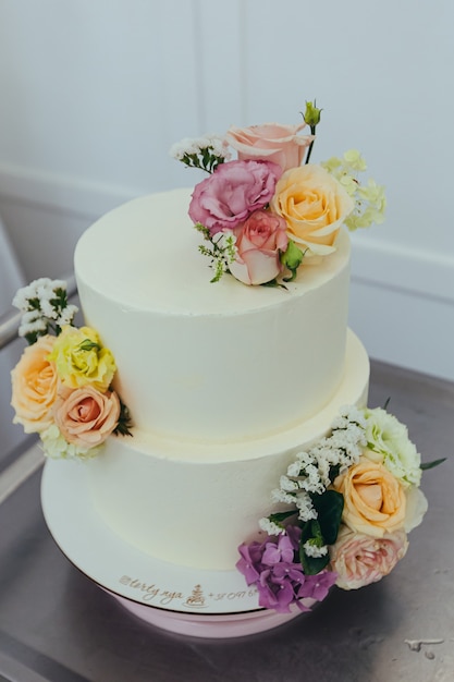 Pastel de bodas en un restaurante blanco decorado con flores frescas