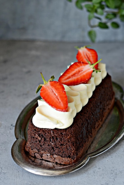 Pastel de brownie de chocolate con crema de vainilla aireada y fresas frescas