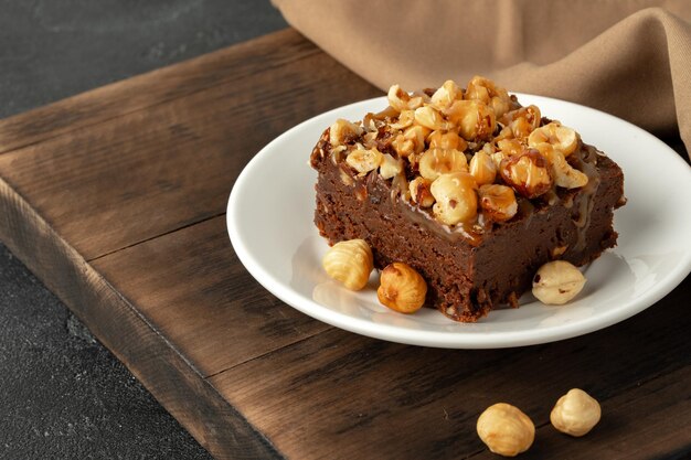 Foto pastel de brownie con cobertura de nueces en un plato de cerca