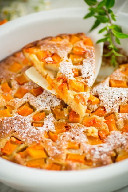 Foto pastel de calabaza dulce con rodajas de calabaza en un molde de cerámica